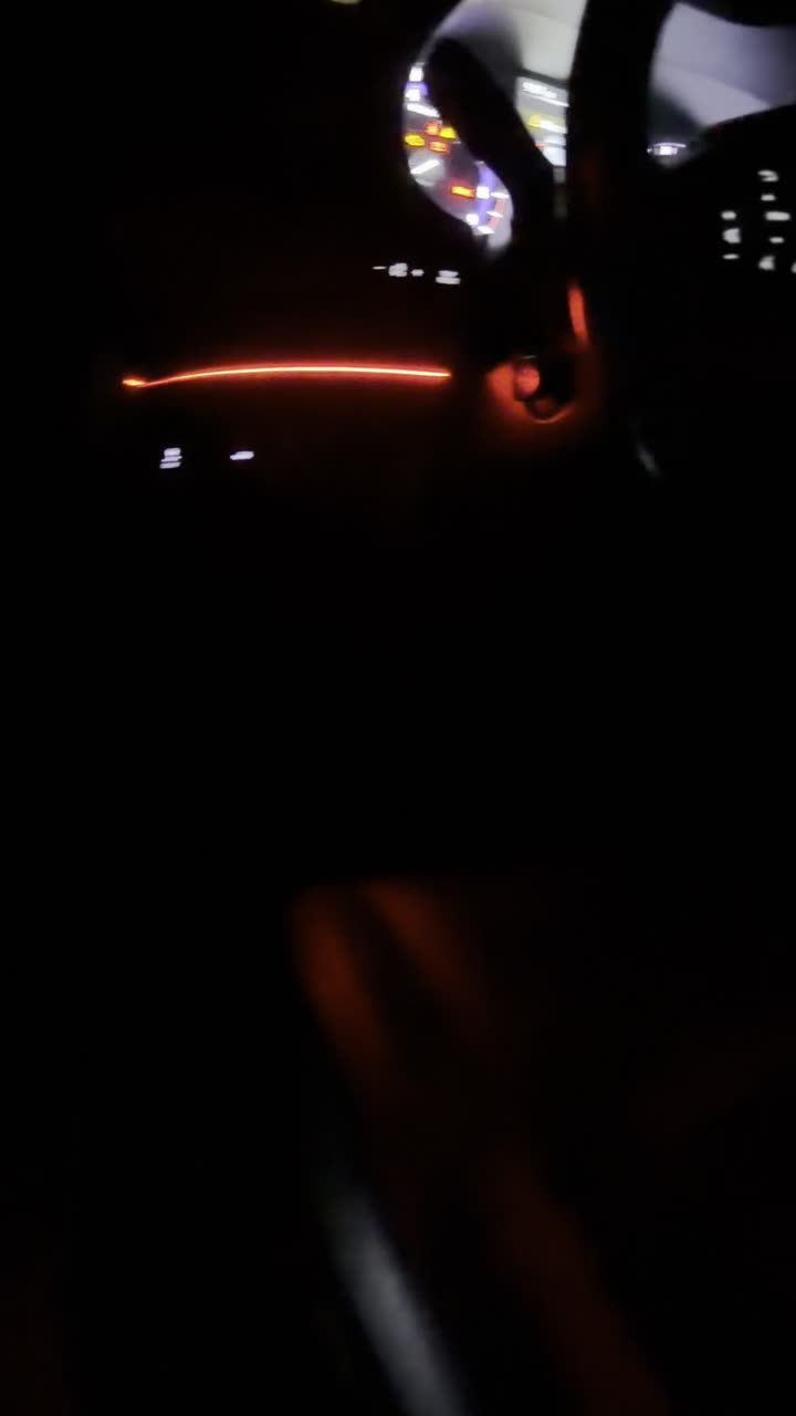 Red ambient light strip glowing on a dash at night