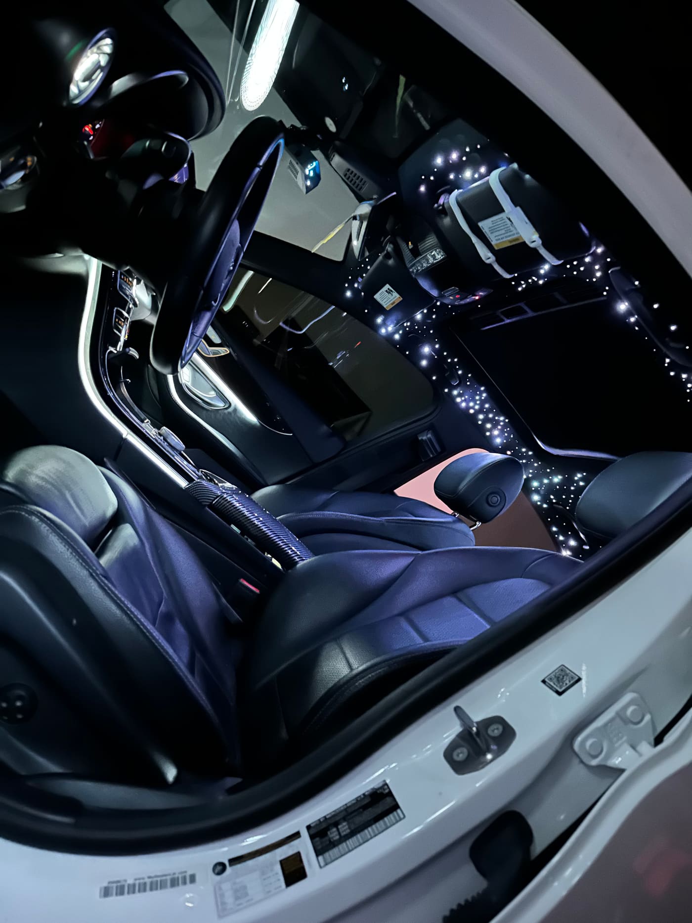 Ice-white starlight headliner over black leather seats in a Mercedes